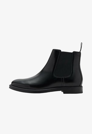 Stivale Chelsea in pelle nera con finitura liscia, altezza alla caviglia, pannelli laterali elastici e una linguetta sul retro per una facile calzata.