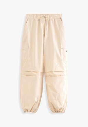 Beżowe spodnie cargo z elastycznym paskiem i sznurkiem do regulacji. Posiadają dwie boczne kieszenie oraz ściągacze przy kostkach. Gładki, lekki materiał.