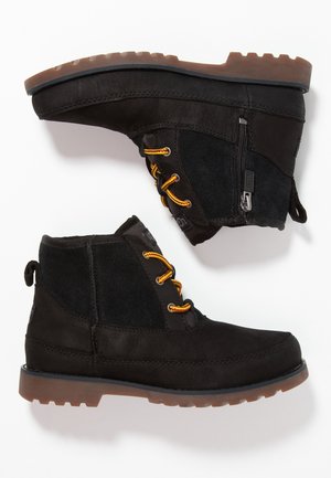 Schwarze Knöchelstiefel aus einer Kombination von Leder und Wildleder, mit gelben Schnürsenkeln und einem seitlichen Reißverschluss, ausgestattet mit einer robusten Gummisohle.