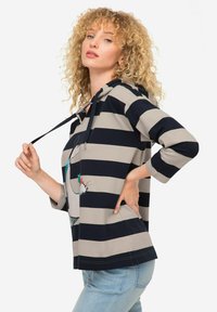 Pullover con cappuccio a righe blu navy e beige, con maniche a tre quarti e un design grafico. Tessuto in misto cotone con una vestibilità rilassata.