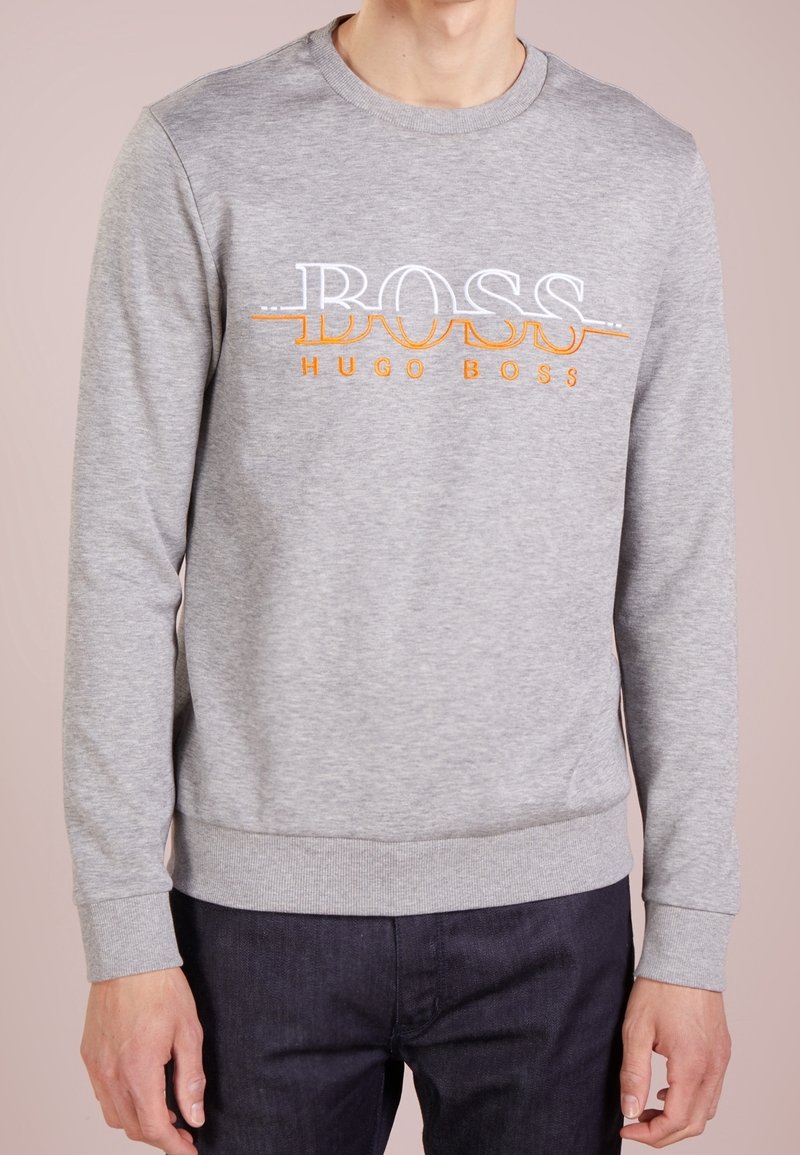 Sweat-shirt gris en mélange de coton, avec un col rond, des poignets côtelés, et le logo brodé "BOSS" en blanc et orange centré sur la poitrine.