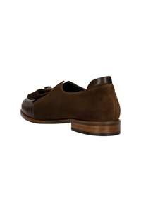 Chaussure en daim marron avec un bout arrondi, un empiècement en cuir et un petit talon en bois. Présente un nœud et un détail en métal argenté. Texture lisse.