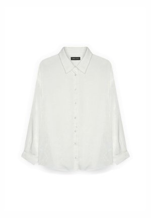 Camisa de manga larga, abotonada en marfil claro, con una textura suave y lisa, y un cuello clásico con mangas enrolladas.