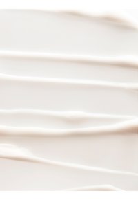 Glatter weißer Creme gleichmäßig in horizontalen Schichten mit sanften Rillen und glänzender Textur verteilt.