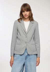Blazer grigio realizzato in morbido misto cotone, presenta un colletto con rever, due tasche frontali e una vestibilità sartoriale con chiusura a due bottoni.