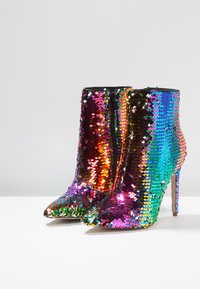 Pailletten enkellaarsjes met een kleurrijk, iriserend ontwerp, een puntschoen en een stilettohak. Zwarte ritssluiting aan de zijkant.