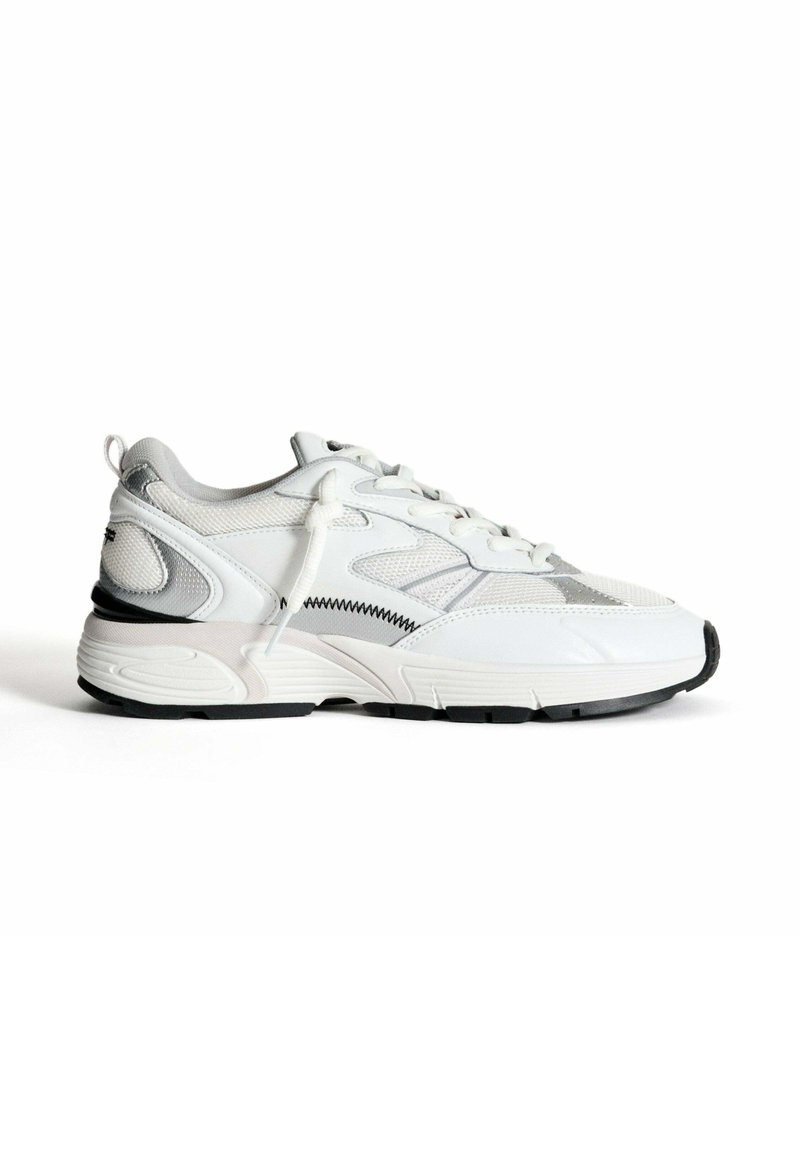 Witte sneaker met een bovenwerk van mesh en synthetisch materiaal, ronde neus, contrasterende grijze accenten, textuur zijpanelen en een zwarte rubberen zool.