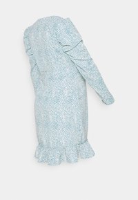 Jasnoniebieska sukienka w kropeczki, z falbaniastymi akcentami przy mankietach i u dołu, wykonana z miękkiego, teksturowanego materiału.