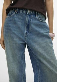 Högmidjade, ljusblå denimjeans med en urtvättad finish, med en femfickdesign och ett subtilt söm mönster längs sömmarna.