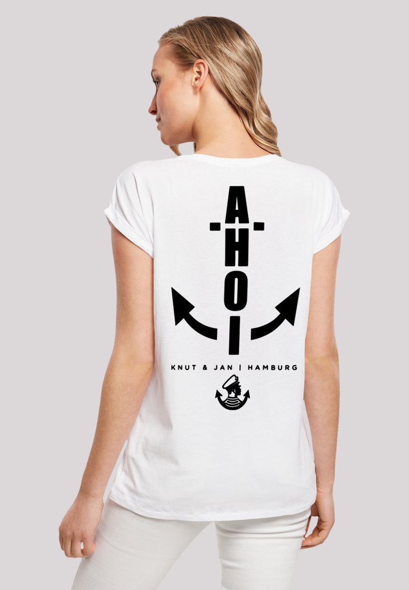 White cotton t-shirt featuring a large black "AHOI" text, anchor and arrows design on the back, with "Knut & Jan | Hamburg" text underneath.