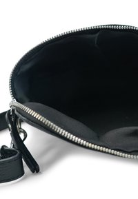 Schwarze Lederhandtasche mit silbernem Reißverschluss. Innenfutter aus schwarzem Stoff. Merkmale: abnehmbarer Schulterriemen und glatte Oberfläche.