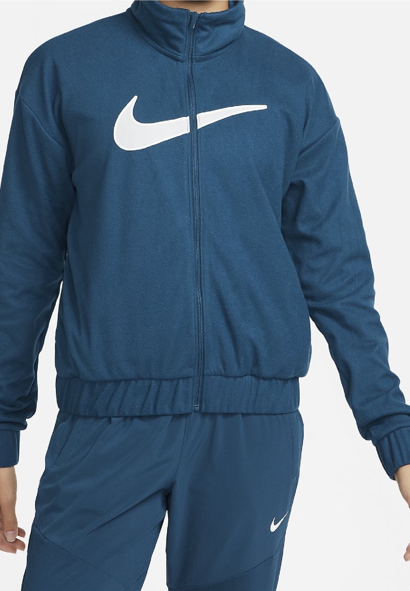 Nike lynlåstrøje i mørkeblå fleecestof med en hvid swoosh-logo på brystet, høj krave samt elastiske manchetter og kant.