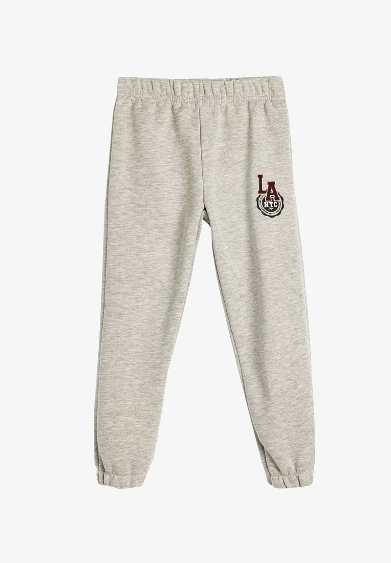 Grå svedebukser lavet af blødt bomuldsblanding, med elastisk talje og mansjetter, og med "LA NYC" broderet i rød og sort.