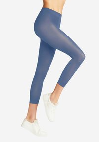 Leggings blu a vita alta realizzati in un materiale elastico e morbido, caratterizzati da una texture liscia e un design cropped, abbinati a sneaker bianche.