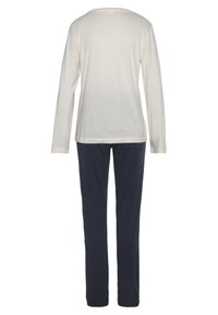 Top de manga larga color beige claro con cuello redondo y pantalones azul marino. Ambos artículos están fabricados con una tela suave y lisa, con un ajuste relajado.
