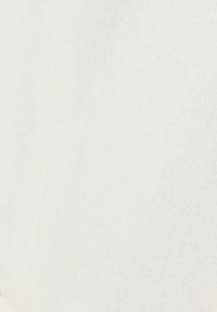 Tejido de lino blanco con una textura suave, que muestra un sutil patrón de tejido natural. No hay acentos ni herrajes notables presentes.