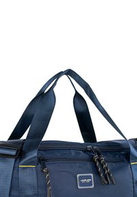 Bolsa de deporte navy fabricada con material de nylon duradero, dos asas trenzadas, compartimento con cremallera y costuras de acento amarillas. Incluye una placa con el logo.