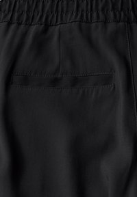 Černá látka s hladkým povrchem, obsahující zadní kapsu a elastický pás se na vrchu nařaseným prošíváním.