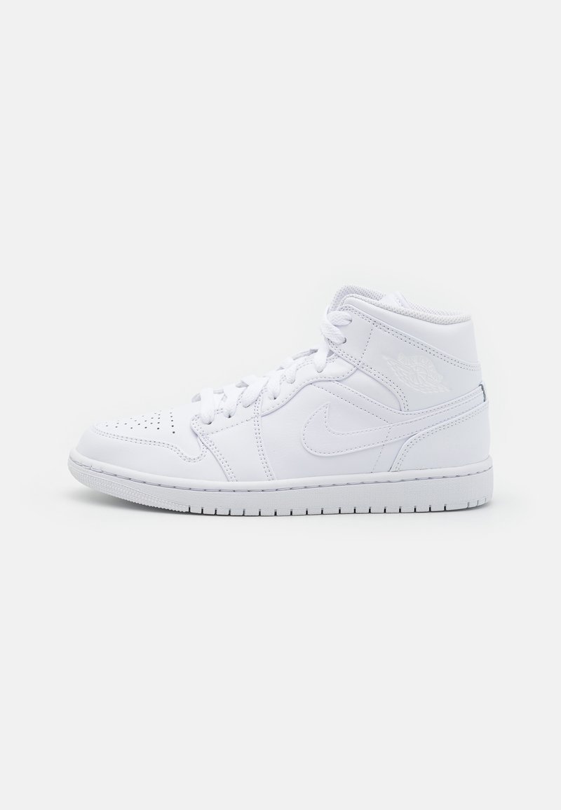 Baskets montantes blanches avec lacets, bout perforé, logo Nike et coutures visibles sur un fond uni clair.