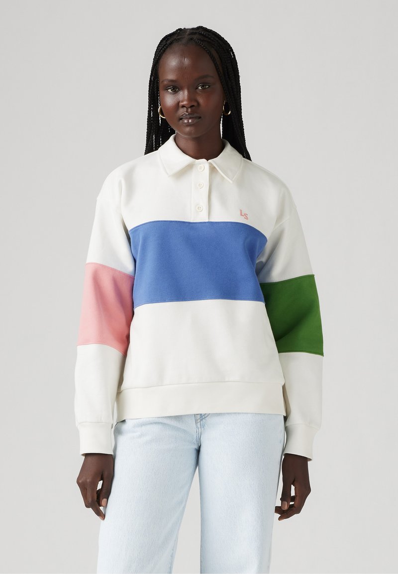 Kremkrāsas polo stila džemperis ar platām horizontālām svītrām zila, rozā un zaļā krāsā. Mīksta audums, ribota aproces un trīs pogu apkakle.