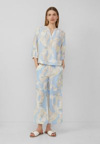 Ensemble de vêtements de détente léger à motifs dans des tons de bleu doux et de beige. Haut ample à manches 3/4 et pantalon large avec poches.