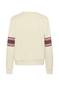 Sudadera de color crema claro con mangas largas, puños acanalados y dobladillo. Presenta rayas de color burdeos en cada manga. Textura de tela suave.