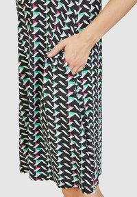 Schwarzes Kleid aus Stoff mit geometrischem Muster in Weiß, Pink und Grün; mit seitlicher Tasche und lockerer Passform.