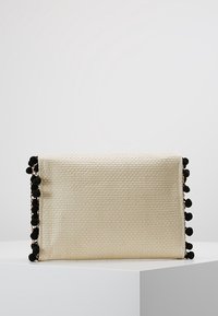 Woven clutch bag w kolorze kremowym, z czarnymi akcentami w postaci pomponów po jednej stronie. Prostokątny kształt z teksturowaną powierzchnią. Kompaktowy i strukturalny design.