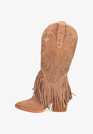 Tan suedine cowboylaar met franjes, decoratieve uitsparingen en studs. Beschikbaar met een spitse neus en een gestapelde hak.