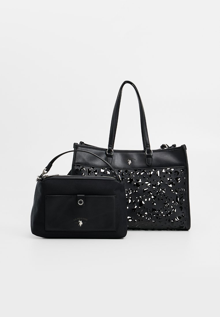 Conjunto de bolso negro que incluye un gran tote con un diseño de corte y un acabado suave, y un pequeño estuche con un bolsillo frontal y cierre de cremallera.