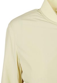 Lys beige genser med høy krage, med glatt, lett stoff og minimalistisk design. Inkluderer flat sømdetaljering.