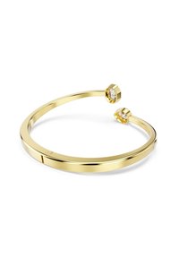 Gouden armband van cuff met een gladde, gepolijste afwerking, met aan elke kant twee hexagonale heldere kristallen. Minimalistisch ontwerp.