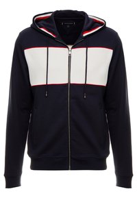 Felpa con cappuccio e zip in blu navy con un pannello anteriore bianco e rosso. Presenta lacci e tasche laterali. Tessuto morbido in misto cotone.