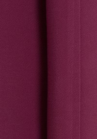 Tissu texturé bordeaux avec un motif de tissage diagonal. Le matériau semble durable, affichant une finition lisse et régulière.