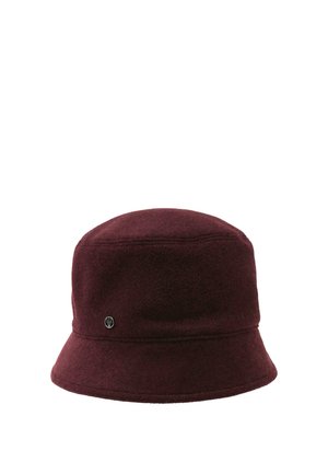 Dark burgundy bucket hat made of soft fabric with a small round metal logo on the side.