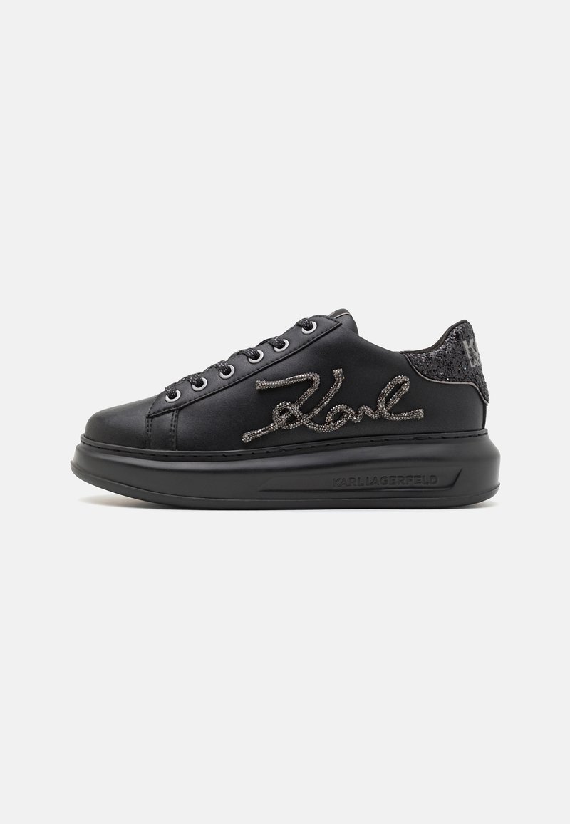Black platform sneaker with rhinestone script logo on the side, glittered heel tab, and embossed brand name on the sole.