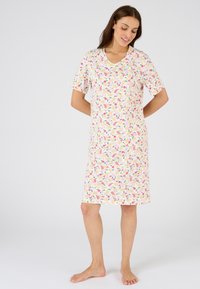 Camisa de noche de manga corta hecha de una tela suave, con un patrón floral en rosa, amarillo y verde sobre un fondo crema, hasta la rodilla.