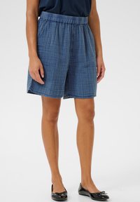 Jeansshorts med elastisk midja, med ett rutigt mönster i blå nyanser, knälånga och tillverkade av ett texturerat material.