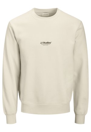 Felpa color crema realizzata in tessuto morbido. Presenta un collo tondo e maniche lunghe. Logo "JJ Studios" stampato in nero sul davanti.