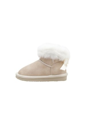 Botte d’hiver en daim beige avec bordure en fourrure blanche duveteuse et petit nœud en tissu à l’arrière, semelle plate, vue latérale.