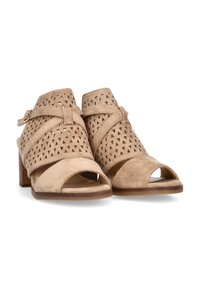 Zapatos beige de punta abierta con tacón bloque, con parte superior de ante perforado, tiras entrelazadas y detalle de hebilla en el tobillo para un ajuste seguro.