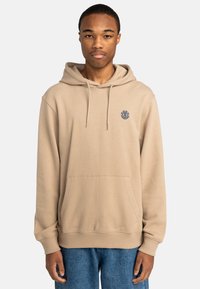 Beige hoodie made of soft material, featuring a front pocket, adjustable drawstrings, and a small logo on the chest. Standard fit.