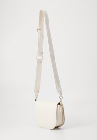 Borsa a tracolla bianca in pelle con patta curva, rifiniture beige a contrasto e una tracolla testurizzata con dettagli del logo. Accenti in hardware dorato.
