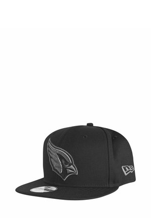 Black baseball cap with a raised gray embroidered bird logo on the front and a flat brim. Features textured fabric and a branded side accent.