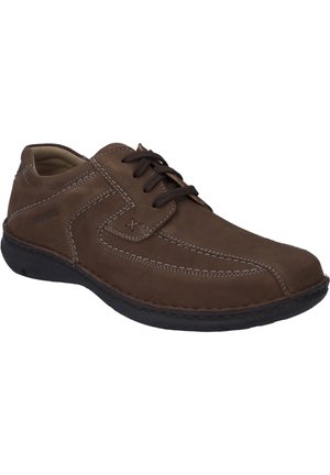 Bruine leren veterschoenen met contrasterende witte stiksels, ronde neus en een flexibele zwarte rubberen zool.
