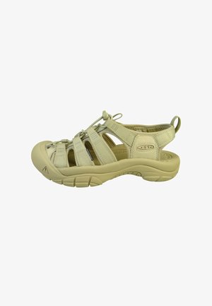 Sandalia de exterior beige con puntera cerrada, tiras ajustables, suela acolchada y lengüeta en el talón para facilitar su uso.