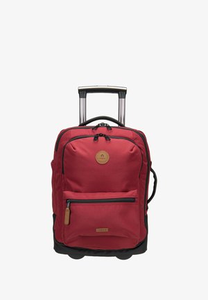Valise cabine rouge à roulettes avec poignée télescopique, poche avant zippée et poignée latérale, debout en position verticale sur fond blanc.