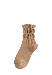 Calzino di colore beige con una parte superiore arricciata a volant, piede liscio e punta rinforzata. Realizzato in un tessuto morbido per garantire comfort.