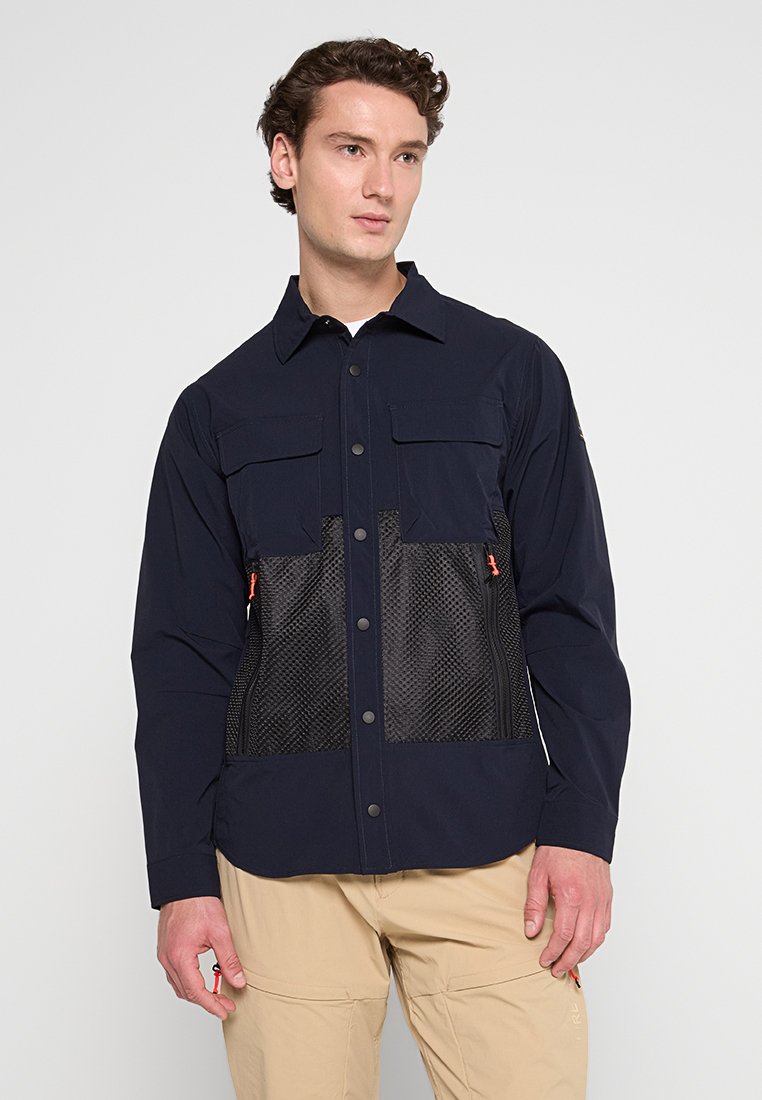 Marineblaues Shirt mit Netzpaneelen an der Vorderseite, zwei Brusttaschen, Druckknöpfen und orangefarbenen Akzenten an der Seite. Glatte Textur.
