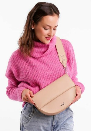 Beige křížová taška s zakřiveným klopou a diskrétním logem, vyrobená z hladkého materiálu. Obsahuje nastavitelné ramenní popruhy a minimalistické designové prvky.